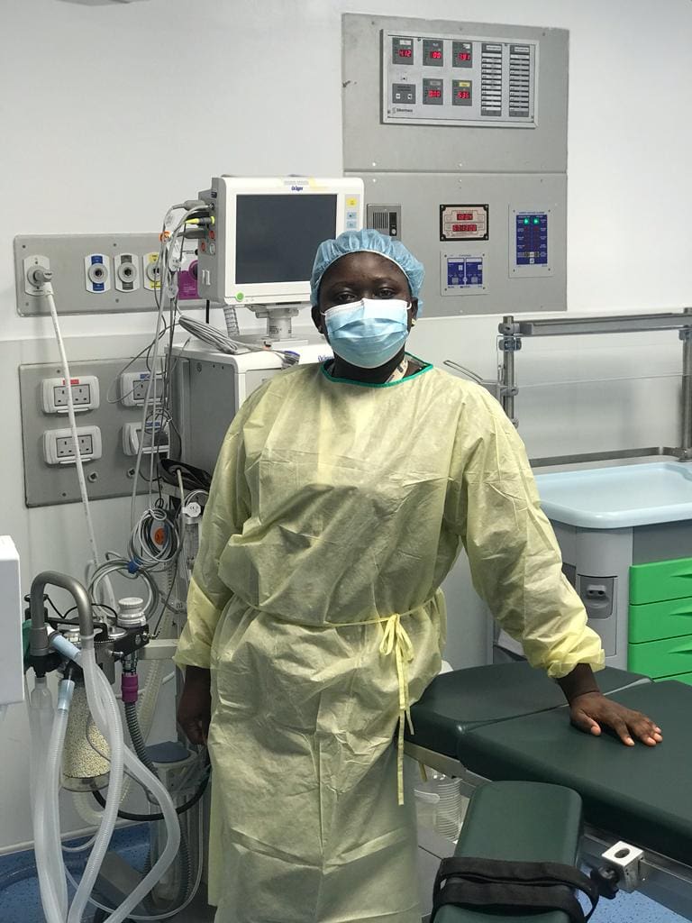 Beatrice Yeboah, manager and mentor of biomedical engineers,  in PPE in front of equipment