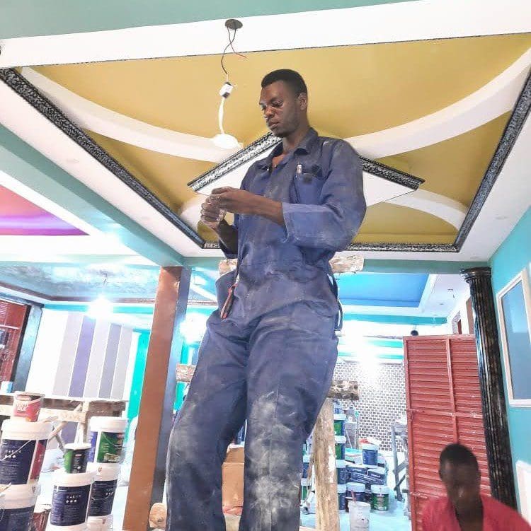Francis Kasendwa installing a light fitting