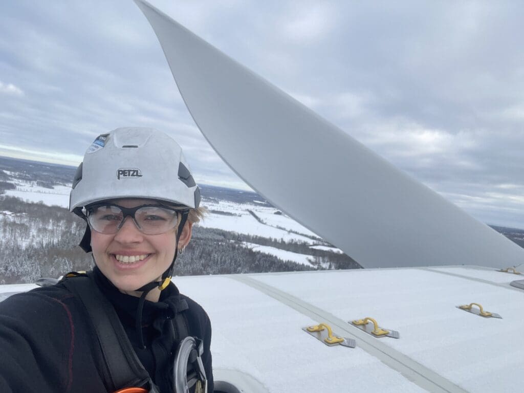 Nathalia Roberta Ferreira Vestas wind turbine technician on top of a turbine with snowy landscape