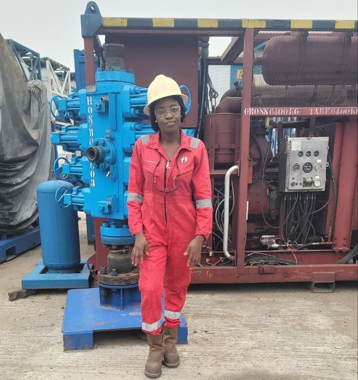 Peninnah Isom Akumute coiled tubing field service engineer Hydroserve standing in front of oil field equipment