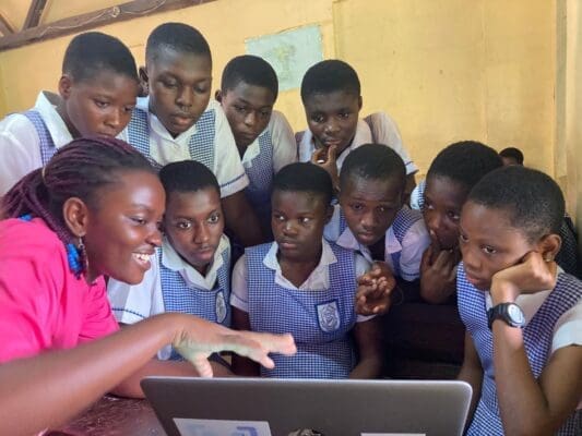 Victoria Mends showing her laptop screen to a group of young children as part of her life as a biomedical engineering student